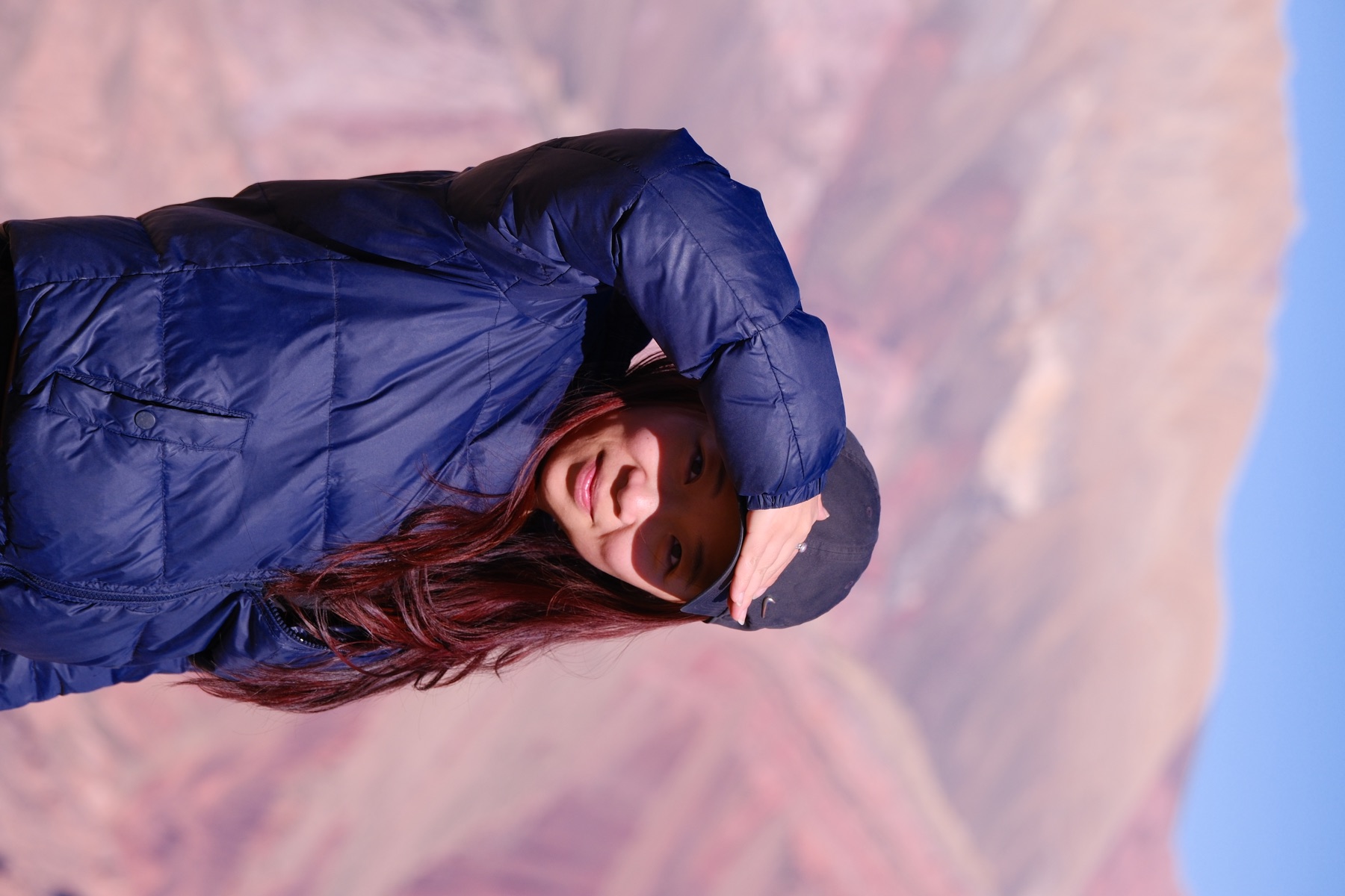 Tianyu shading her eyes in front of rose-coloured mountains